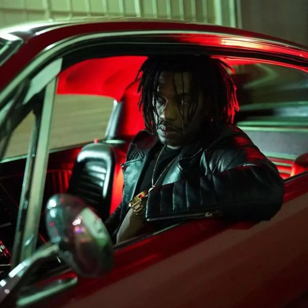 Hip-hop artist Ben Kenobe sitting in a red car